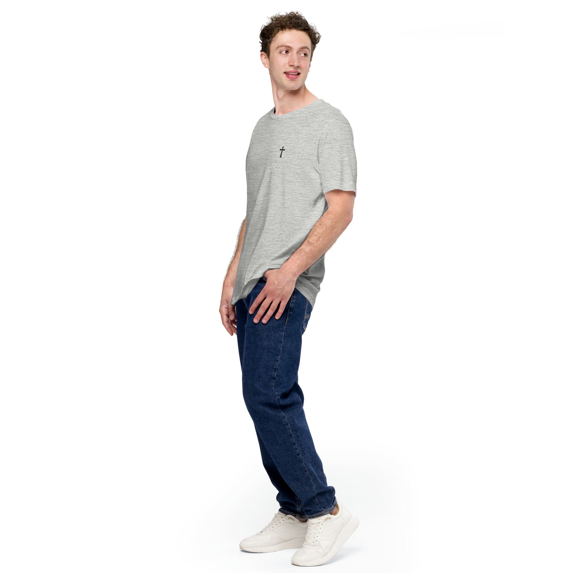Man wearing a gray t-shirt with a logo and blue jeans on a white background